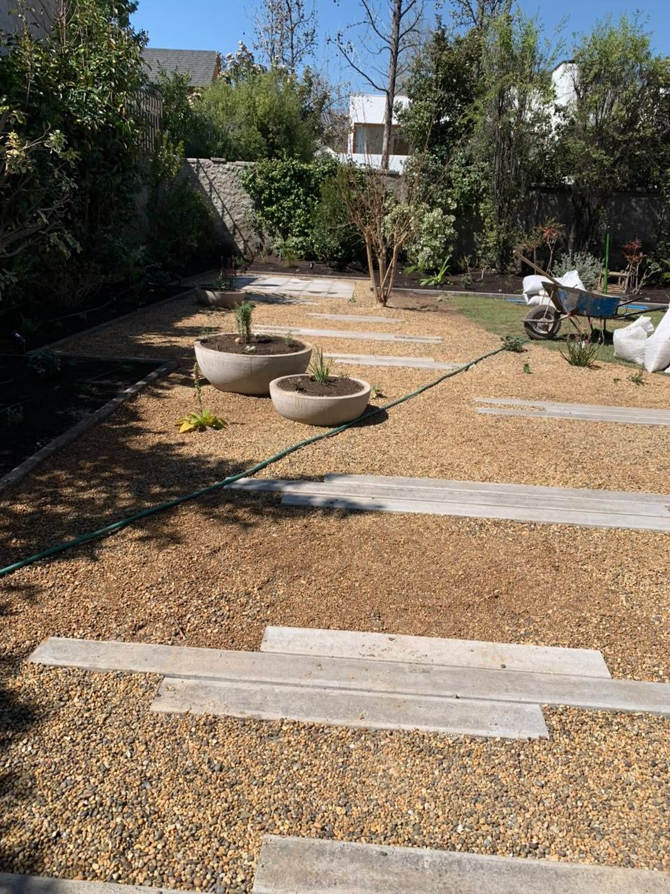 Jardín con gravilla, durmientes y maceteros